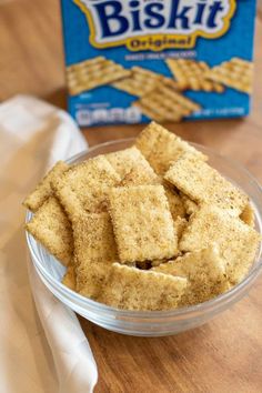 crispy crackers in a glass bowl next to a box of biscuits