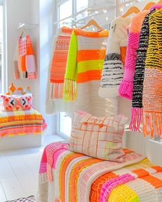 colorful blankets and pillows on display in a room