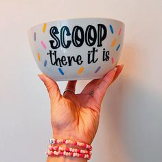 a hand holding up a bowl with the words scoop there is on it and sprinkles all over it