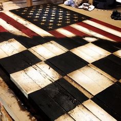 an american flag painted on top of a checkerboard floor in a workshop with tools