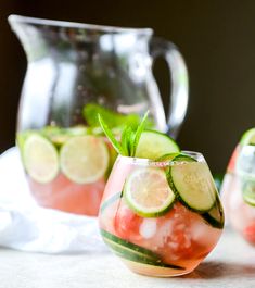 two glasses filled with watermelon and cucumber on top of a table