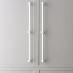 a white cabinet with two handles and knobs