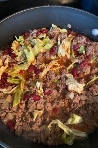 a pan filled with meat and vegetables on top of a stove next to an oven