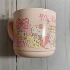 a pink cup with hello kitty on it