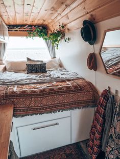 a bedroom with a bed, mirror and rugs on the floor in front of it