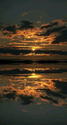 the sun is setting over water with clouds in the sky and reflecting on the surface