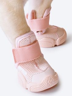 a close up of a person's feet wearing pink shoes with straps on them