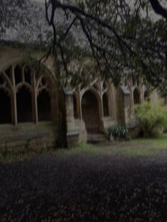 an old building with columns and arches in the middle of it, surrounded by trees