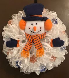 a snowman wreath with orange and blue decorations