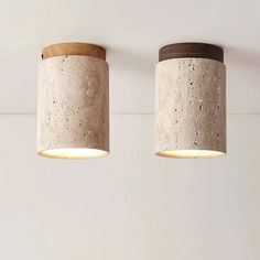 two concrete lamps are hanging from the ceiling