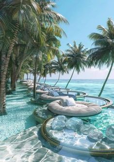 an outdoor swimming pool with lounge chairs and palm trees in the background, surrounded by clear blue water