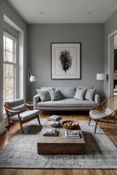 a living room filled with furniture and a painting hanging on the wall above a coffee table