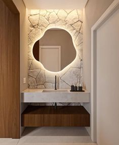 a bathroom with a sink, mirror and light on the wall above it's counter