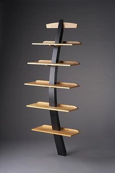 a wooden and metal book shelf with five shelves on each side, in front of a black background