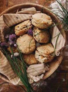 a wooden bowl filled with biscuits and wildflowers