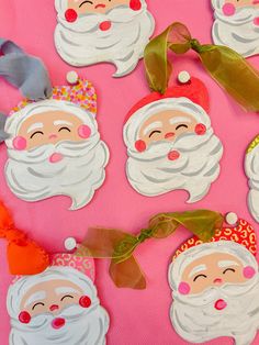 paper santa claus ornaments on a pink background