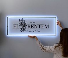 a woman holding up a sign that says florentem flowers and coffee on it