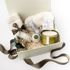 an open gift box containing a candle, candlestick and some other items