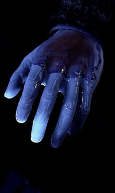 a person wearing blue gloves and holding their hand up in the air with water on it