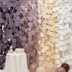 there is a cake on the table in front of some decorative wall paper and balloons