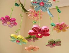 colorful paper flowers are hanging from the ceiling