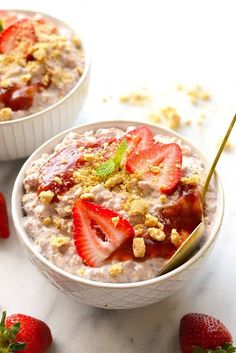 two bowls filled with oatmeal and strawberries