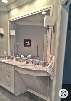 a large bathroom with two sinks and mirrors