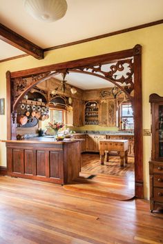 a kitchen with wooden floors and an arched doorway leading to the dining room area is shown