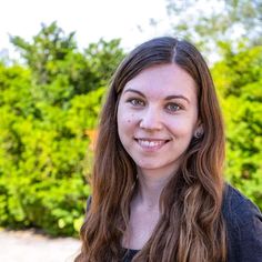 a woman with long hair is smiling at the camera