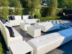 an outdoor seating area with white couches and checkered flooring in the background