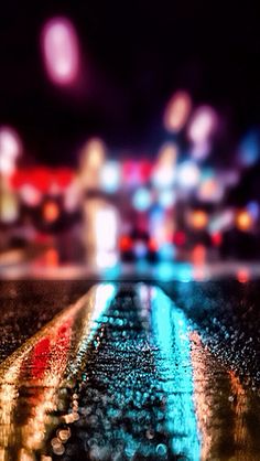 blurry image of city street at night with lights and buildings in the back ground