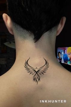 the back of a woman's neck with a bird tattoo on her left side