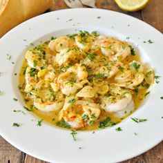 a white plate topped with pasta and shrimp