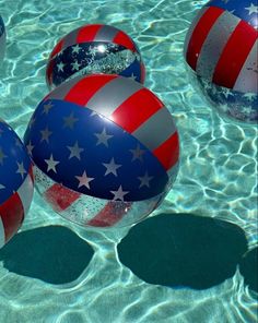 three patriotic beach balls floating in the water