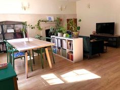 a living room filled with furniture and a flat screen tv on top of a wooden table