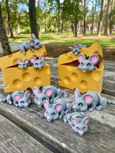 some little mouses are sitting on a picnic table with cheese in the shape of mice