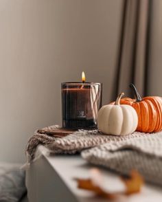 a candle and some pumpkins on a table