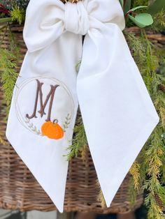 "Decorate your front door with a  wreath sash.   This wreath has the elegant monogram in beautiful fall colors framed with a pumpkin embroidery. Our sashes can be customized for any season with a variety of colors.  Sash will feature the pumpkin frame monogram on one tail.    *Sashes come in three lengths, 44\" , 54\" , 74\" *5\" width *Machine Washable *linen These are perfect for baby decor, basket decor, and so much more." Sew A Wreath Sash, Fall Wreath Sash, Wreath With Sash, Wreath Sash Monogram, Fall Monogram Wreaths For Front Door, Fall Applique Designs, Fall Applique, Purple Petunias, Fall Door