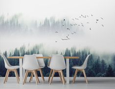 two chairs and a table in front of a forest wall mural