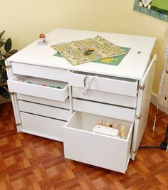 a white desk with drawers and a quilt on top