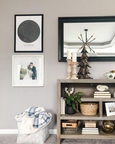 a book shelf with pictures on the wall and a mirror in the corner above it