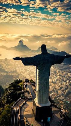 the statue of christ stands in front of a cityscape