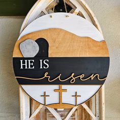 a wooden sign with the words he is risen on it's front and side