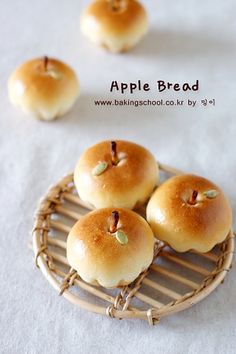 four small bagels sitting on top of a wire rack next to two smaller rolls