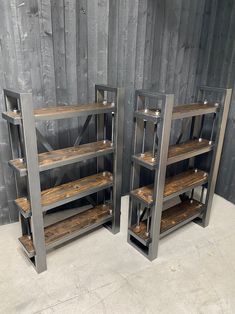 two metal and wood shelving units against a wooden wall