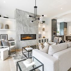 a living room filled with furniture and a fire place in the middle of it's wall