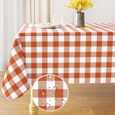 an orange and white checkered table cloth on a wooden table with yellow flowers in the background