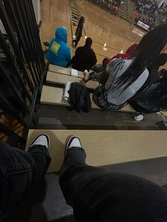 people are sitting on the bleachers at a basketball game