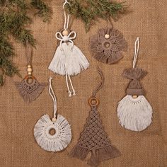 four ornaments are hanging from a tree branch