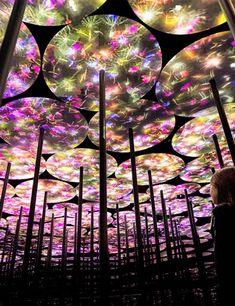 a woman standing in front of a colorful ceiling